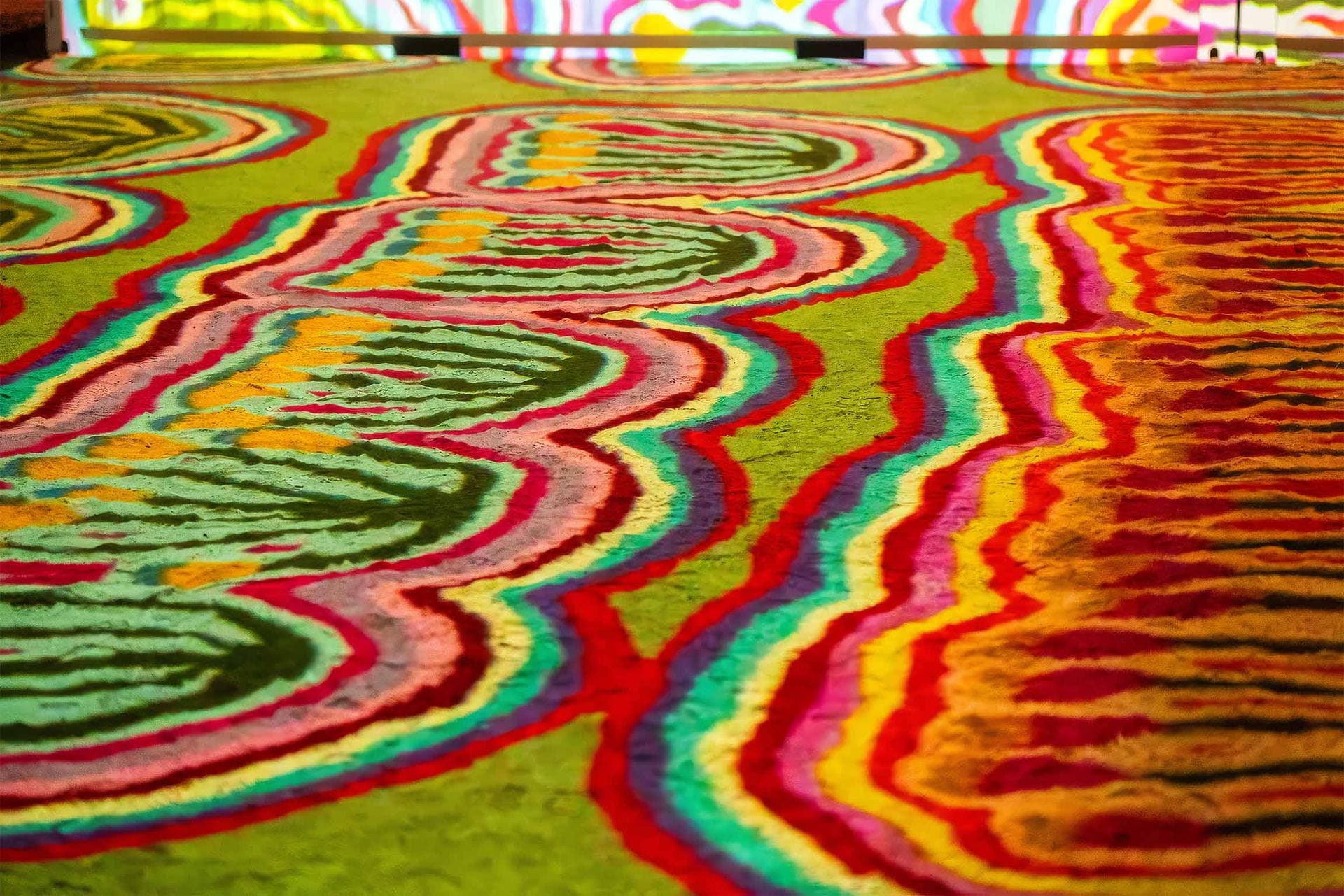 Colorful abstract pattern with wavy lines and vibrant hues, including green, red, blue, and yellow, creating an intricate, eye-catching design.